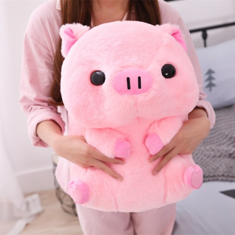 A person holding the pink piggy plushie in their arms, illustrating the size of the plushie in relation to an adult.