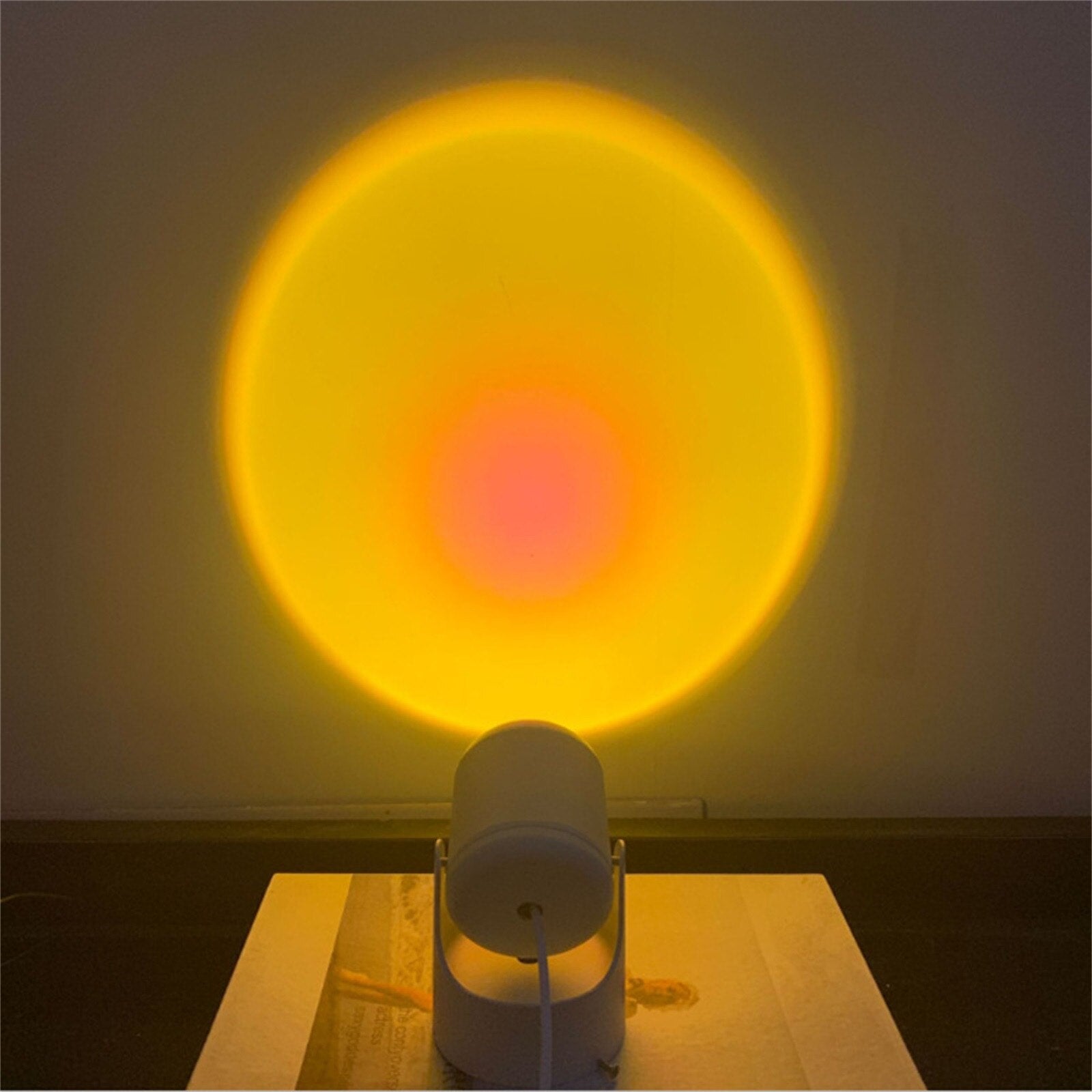 Sunset projector lamp projecting a large, bright, yellow-orange glow on a wall, providing a warm and inviting light source for a vintage room or boho room decor.