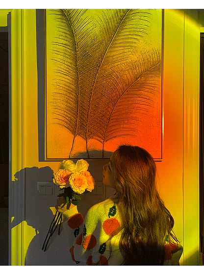 Aesthetic sunset projector shining a golden light on a young woman holding a bouquet, creating a silhouette against the warm backdrop. This scene captures a magical moment perfect for a vintage room or as part of a cozy cottagecore living room.