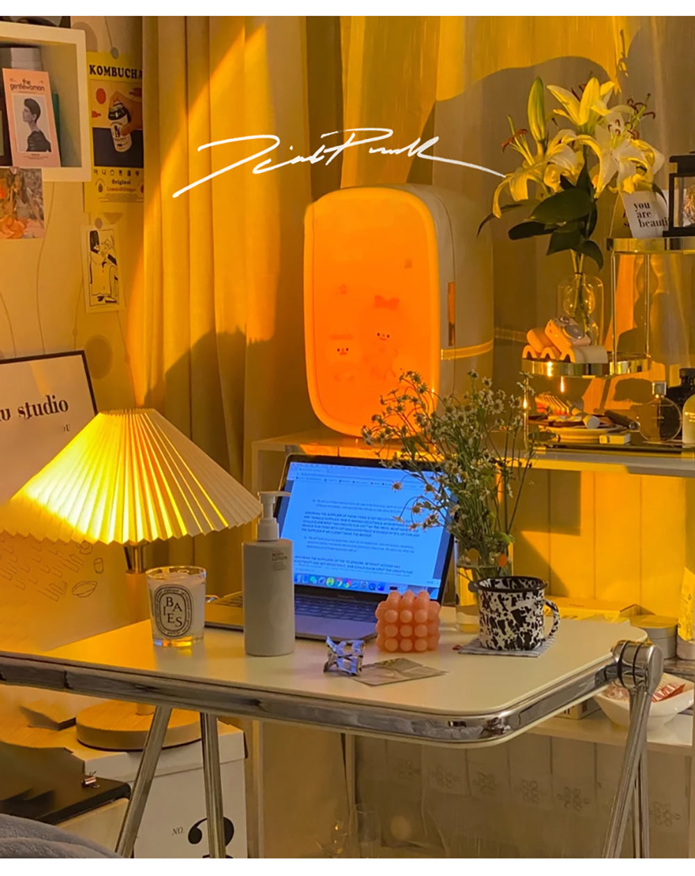 A home office basked in a sunset projector's light, featuring a desktop with a laptop and personal items, complemented by ambient lighting and cozy room accents.