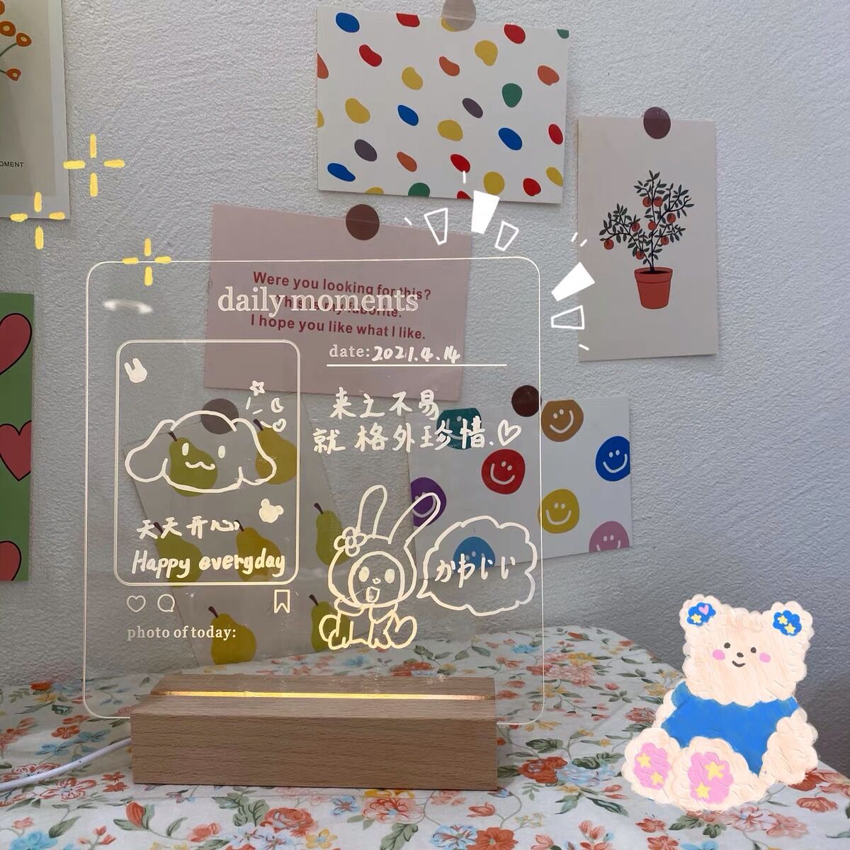 A playful and inviting LED memo board with handwritten notes and cute illustrations, illuminated by a soft backlight. The clear board is part of a cheerful room setup, complete with colorful wall decorations and a plush toy, radiating a joyful and welcoming atmosphere.