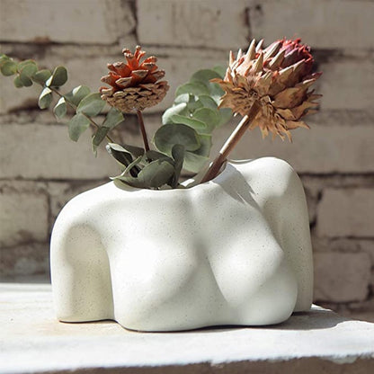 A view of the ceramic vase on its side, now serving as a planter with two blooming succulents, emphasizing the functional art aspect of the piece.