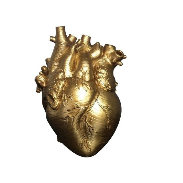 A gold-colored ceramic vase with the texture and form of a human heart, presenting a luxurious and bold decorative piece.
